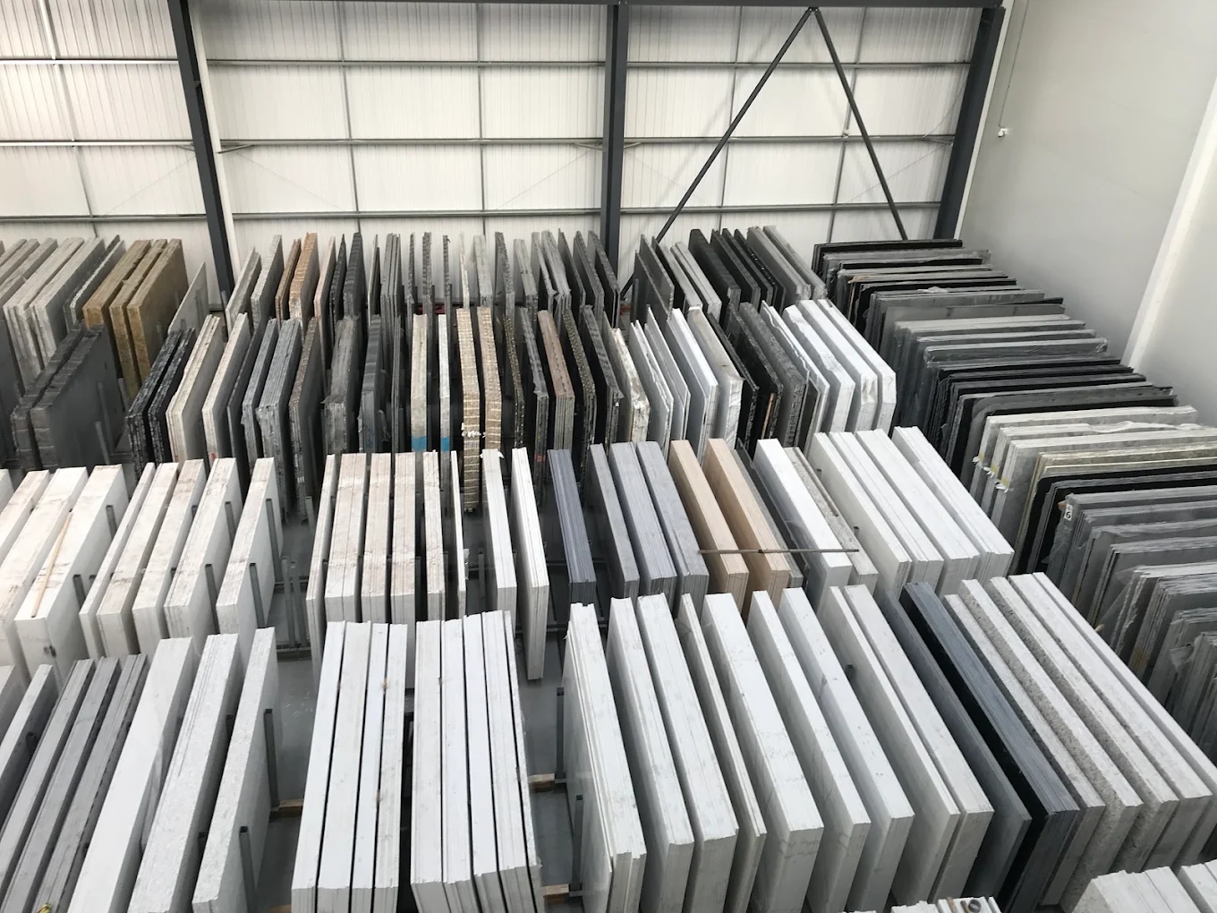 Rows of quartz, granite and marble slabs racked in the Nile Stone warehouse